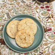 Overhead view of a plate of Chai Spiced Snickerdoodle Cookies with a bowl of whole spices in the background.