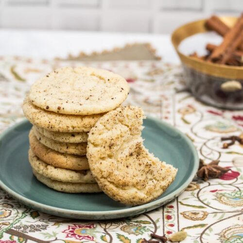 ¾ view of a plate of Chai Spiced Snickerdoodle Cookies with a bowl of whole spices in the background.