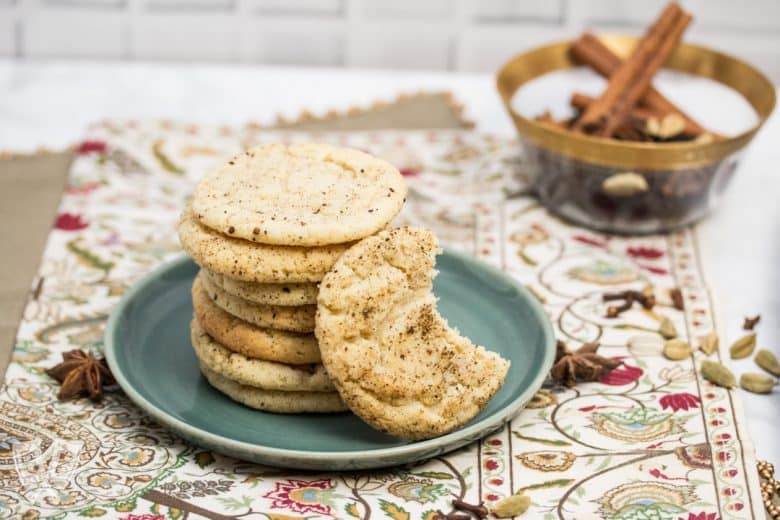 ¾ view of a plate of Chai Spiced Snickerdoodle Cookies with a bowl of whole spices in the background.