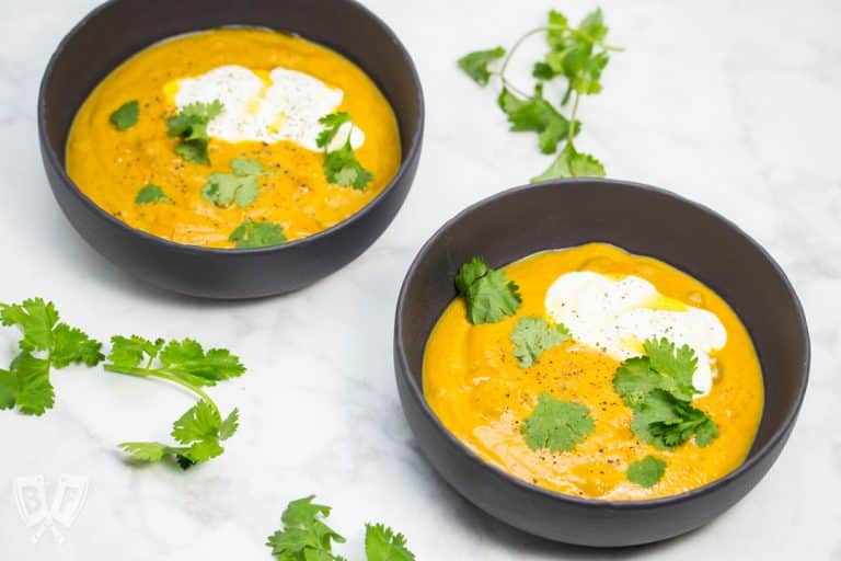 Bowls of curried pumpkin soup garnished with cilantro.