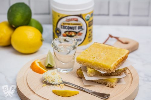A stack of dessert bars with a shot of tequila, fresh citrus, and a jar of butter flavored coconut oil.