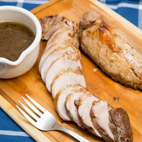 Overhead view Balsamic Marinated Pork Tenderloin carved on a cutting board.