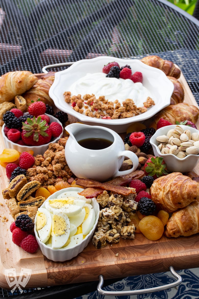 ¾ view of a board of assorted breakfast items sitting on an outdoor table.