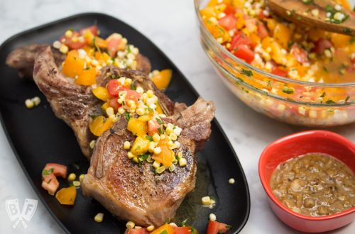 Platter of Sous Vide Double Cut Pork Chops with Raw Summer Corn & Tomato Salad with gravy served alongside.