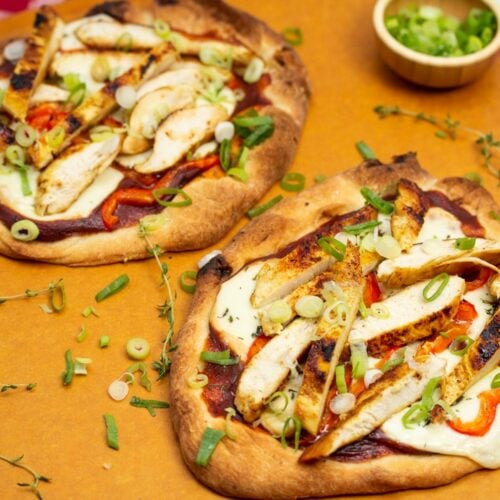 Overhead view of BBQ Chicken Pizza with Smoked Mozzarella on a pizza peel.