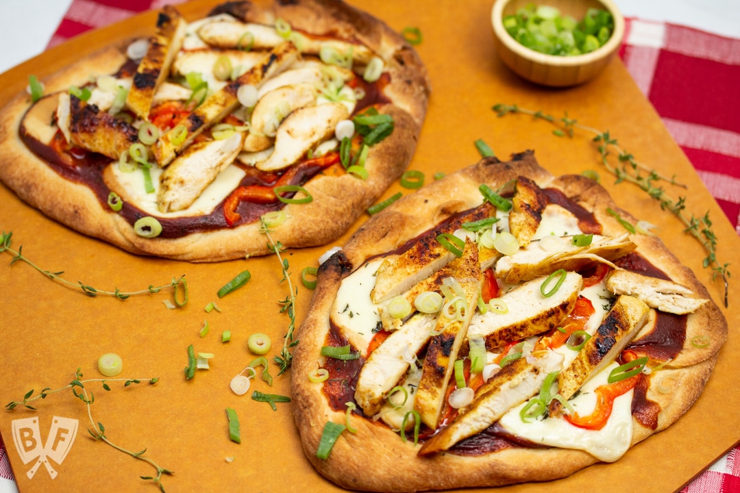 Overhead view of BBQ Chicken Pizza with Smoked Mozzarella on a pizza peel.