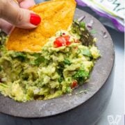 Tortilla chip scooping up guacamole.