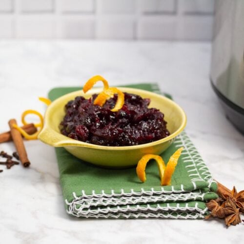 ¾ view of a bowl of Spiced Cranberry Sauce with Bourbon next to an Instant Pot.