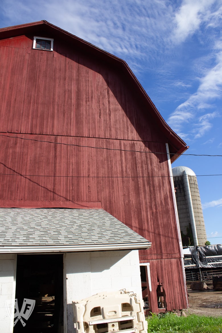 Big red barn against a blue sky on a dairy farm.