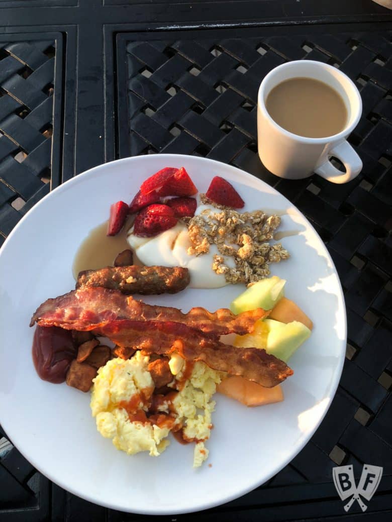 Overhead view of a plate of breakfast foods and a cup of coffee.