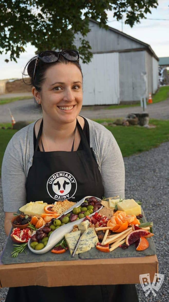 Food blogger holding a cheese board.