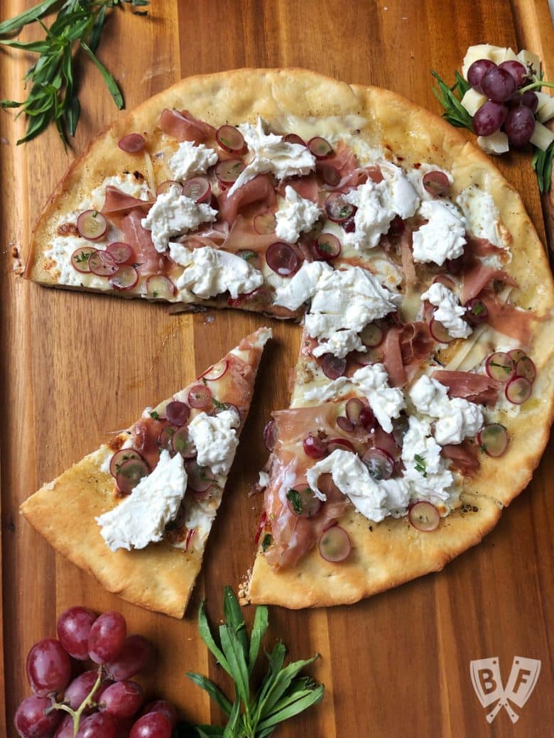 Overhead view of Burrata Pizza with Prosciutto and Pickled Grapes.