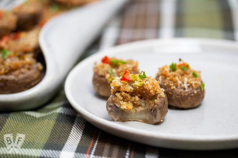 Close-up view of a stuffed mushroom caps with a bite taken out of one of them.