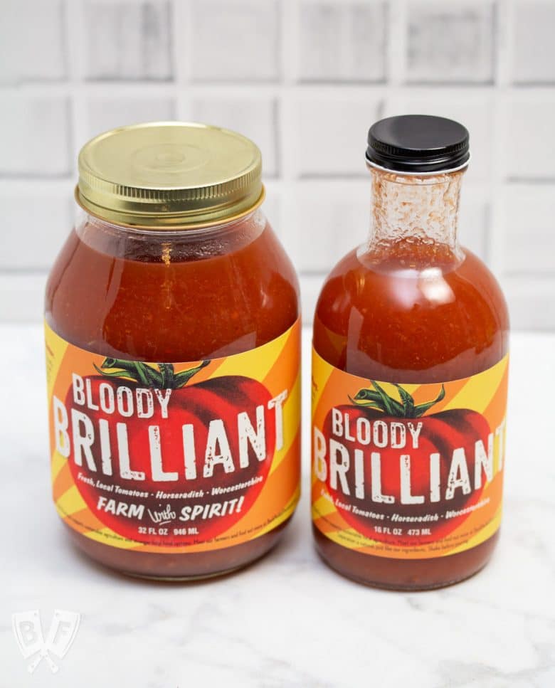 Side view of a jar and a bottle of Bloody Mary mix.