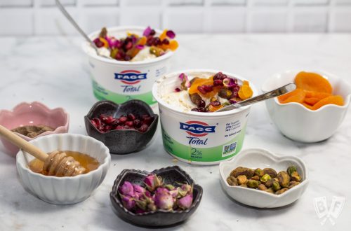 3/4 view of yogurt cups with an array of Persian toppings for making jeweled yogurt parfaits.