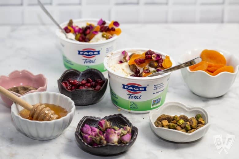 ¾ view of yogurt cups with an array of Persian toppings for making jeweled yogurt parfaits.