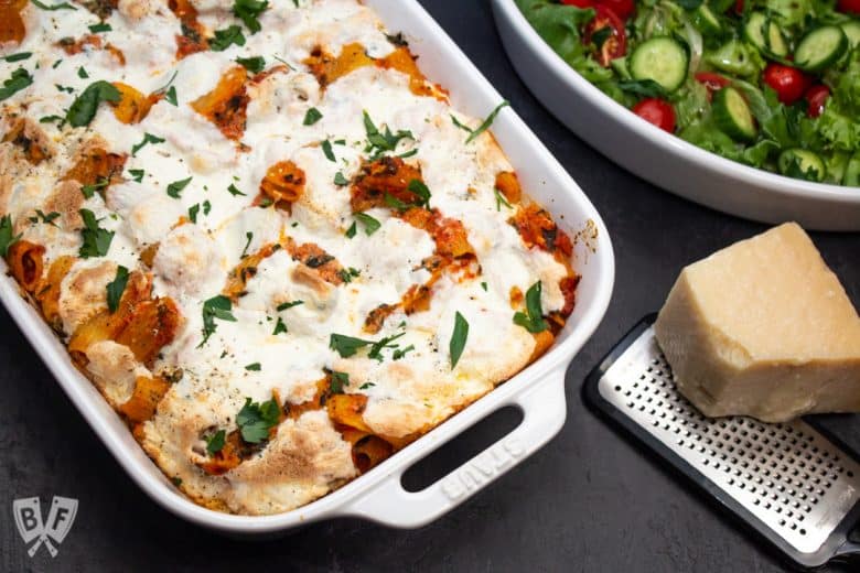 Baked rigatoni pasta casserole with Parmesan and a salad on the side.