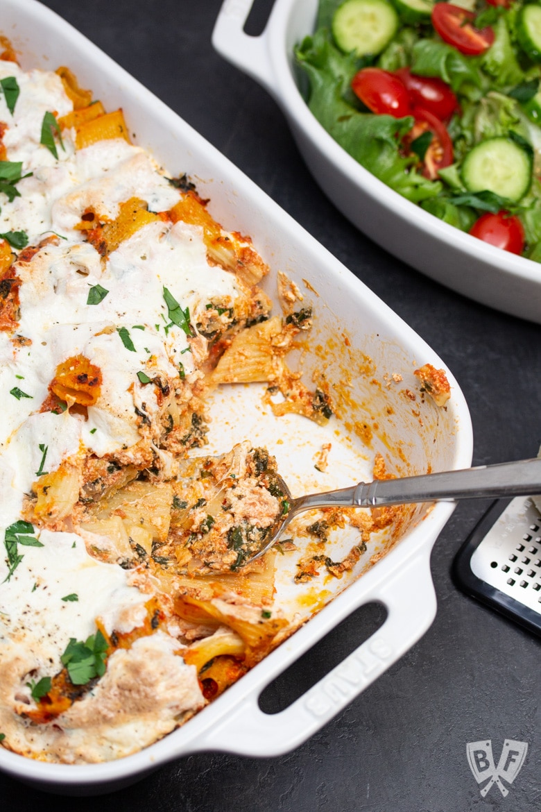 Baked rigatoni pasta casserole with Parmesan and a salad on the side.