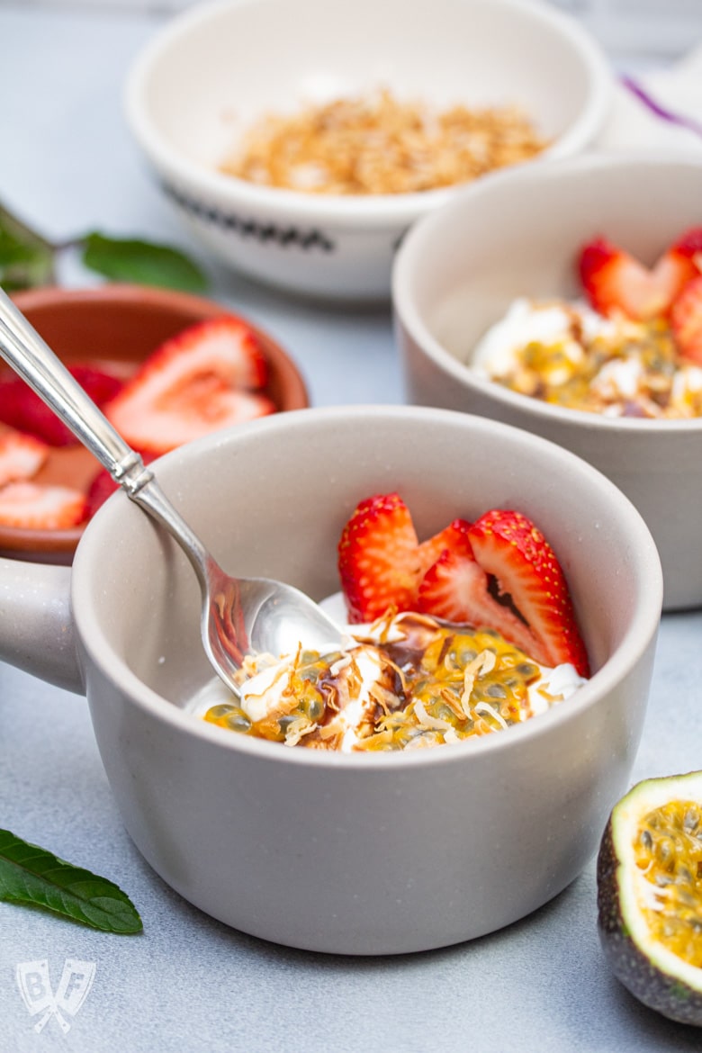 Close-up of Greek yogurt parfaits with colorful tropical fruit toppings.