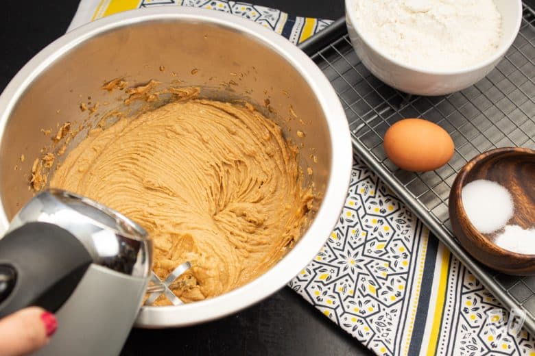 Creaming ingredients for peanut butter cookies with a hand mixer