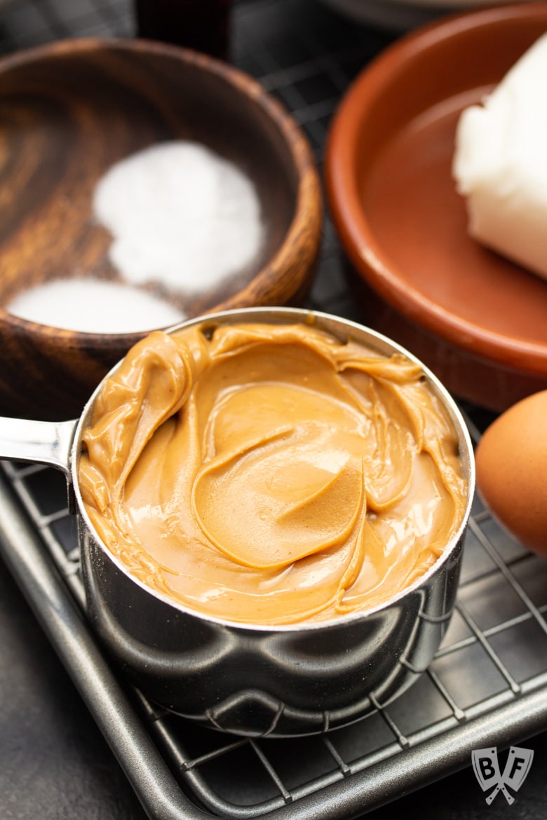 Close up of a measuring cup of creamy peanut butter