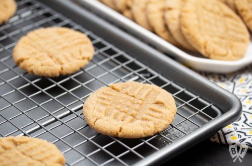 Peanut butter cookies cooling on a baking sheet