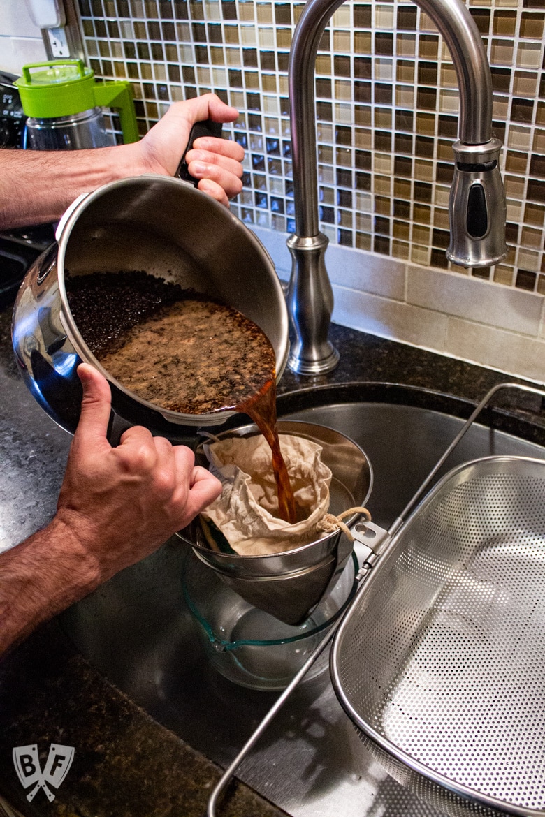 Straining a batch of cold brew coffee