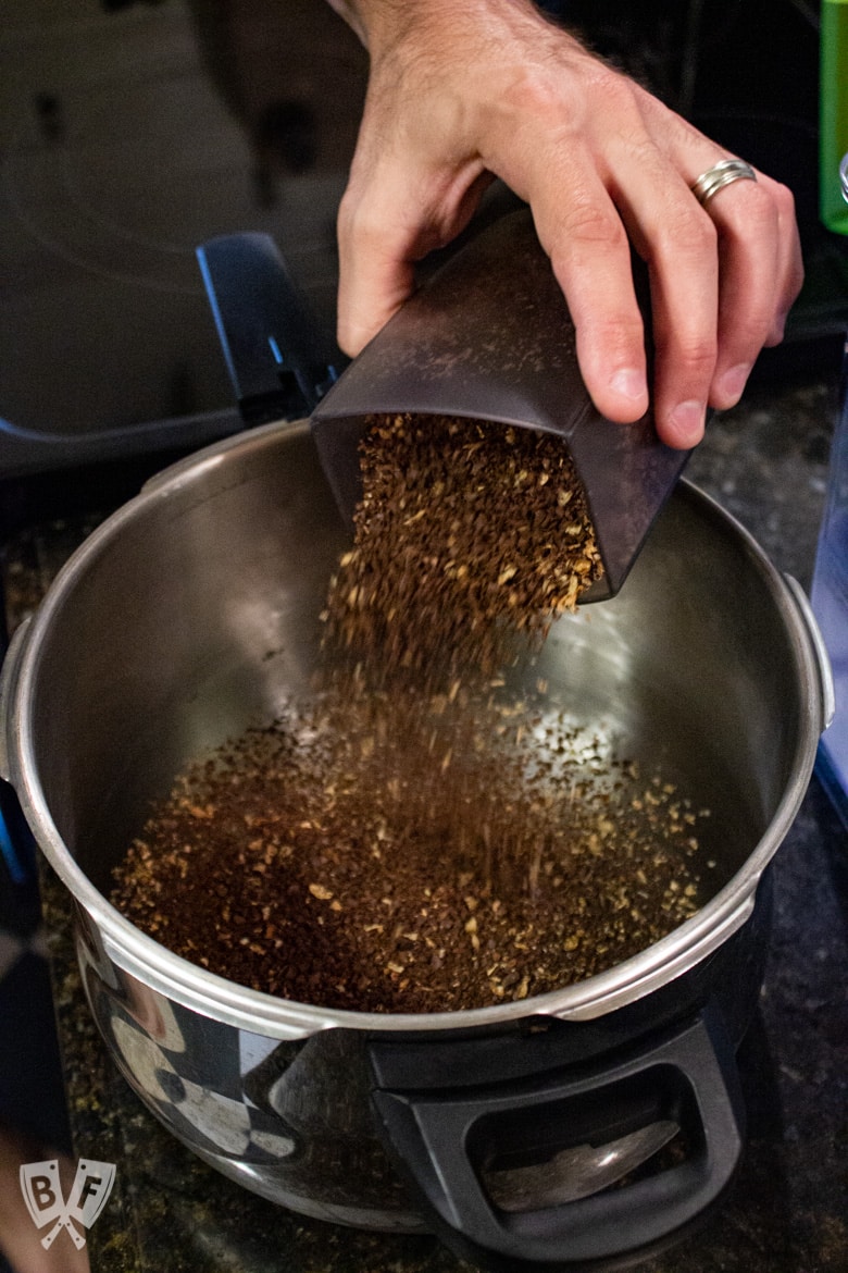 Pouring coarse ground coffee into water for homemade cold brew