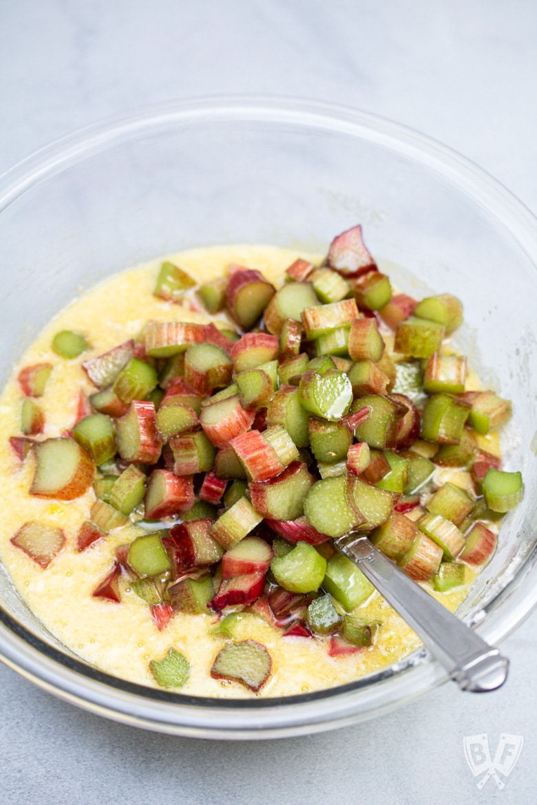 Sliced rhubarb in a bowl of custard for pie.