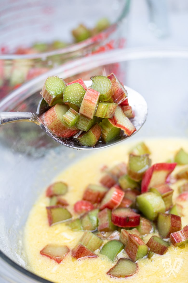 Spooning sugared rhubarb into a custard mixture.