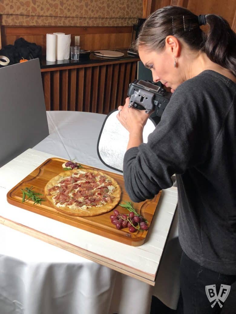 Photographer shooting photos of Burrata Pizza with Prosciutto and Pickled Grapes