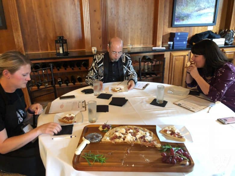 Judges eating Burrata Pizza with Prosciutto and Pickled Grapes during a cooking competition