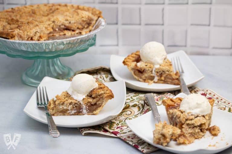 Plates of Dutch apple pie with vanilla ice cream on top.