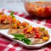Platter of Italian Bruschetta with bowl of tomato mixture in the background