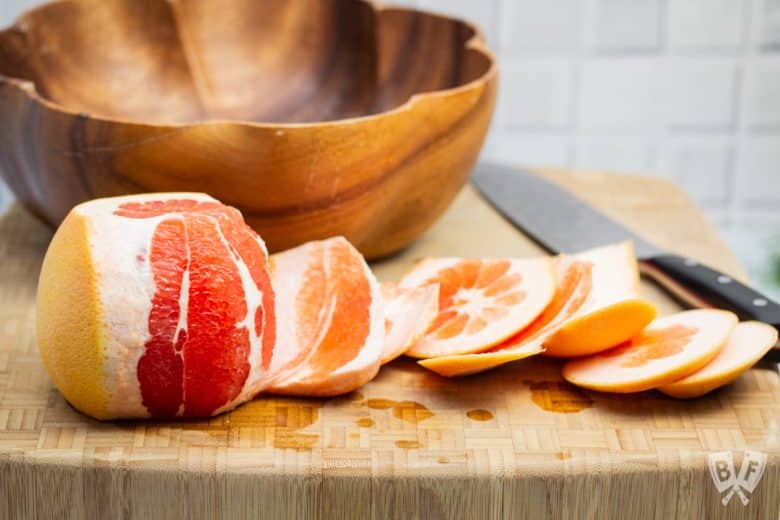 Cutting the rind off of a grapefruit.