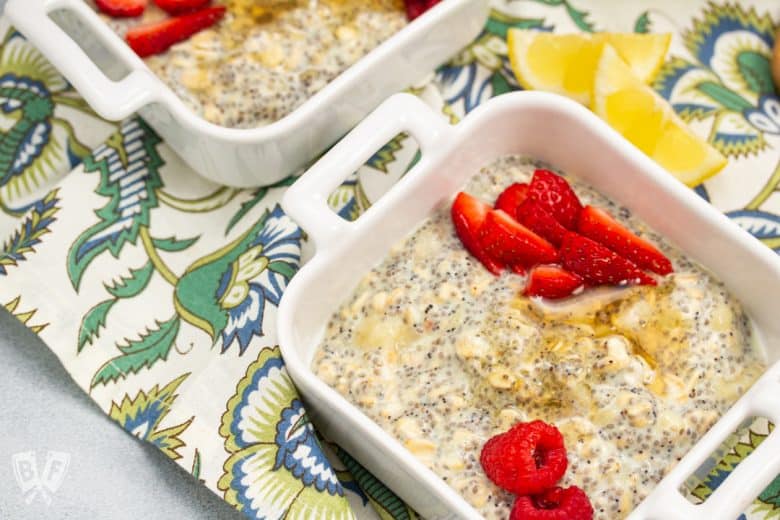 Overhead view of bowls of Lemon Poppy Seed CBD Chia Pudding garnished with fresh berries and honey