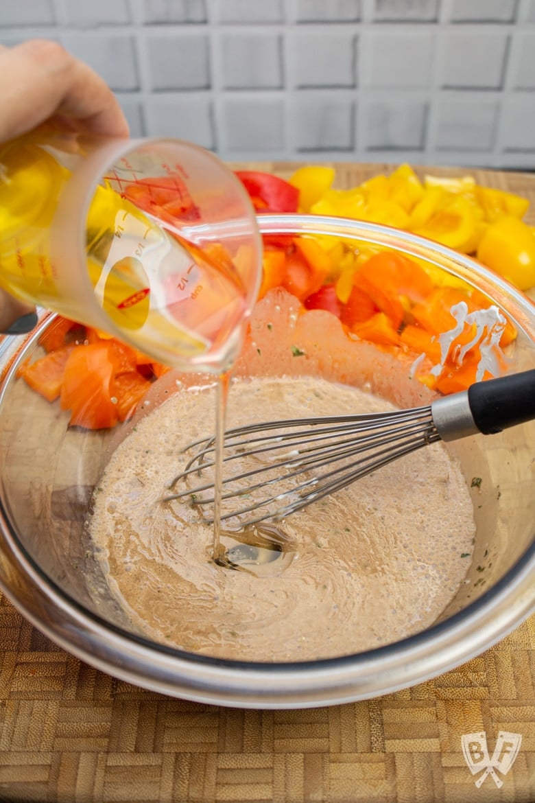 Whisking a bowl of ingredients to make creamy balsamic vinaigrette.
