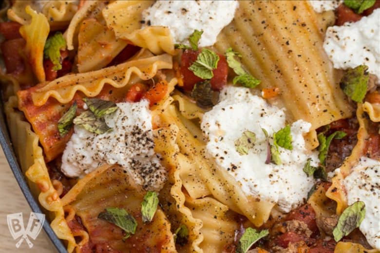 Overhead view of a skillet lasagna with lamb, ricotta, and mint.