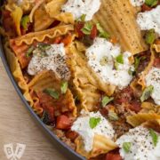 Overhead view of a skillet lasagna with lamb, ricotta, and mint.