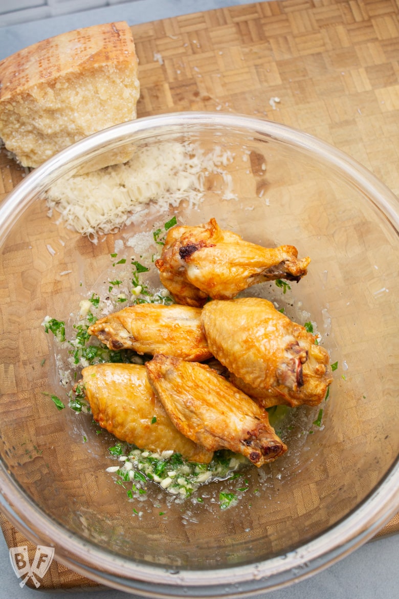 Bowl of air fried chicken wings on top of garlic Parmesan sauce