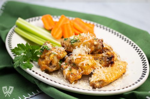 Plate of air fryer garlic parmesan chicken wings with carrots and celery.