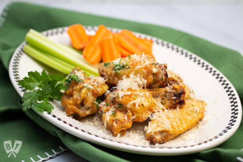 Plate of air fryer garlic parmesan chicken wings with carrots and celery.