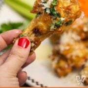 Hand holding a garlic parmesan chicken wing