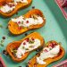 Roasted Honeynut Squash with Burrata, Pomegranate + Pepitas in a baking dish