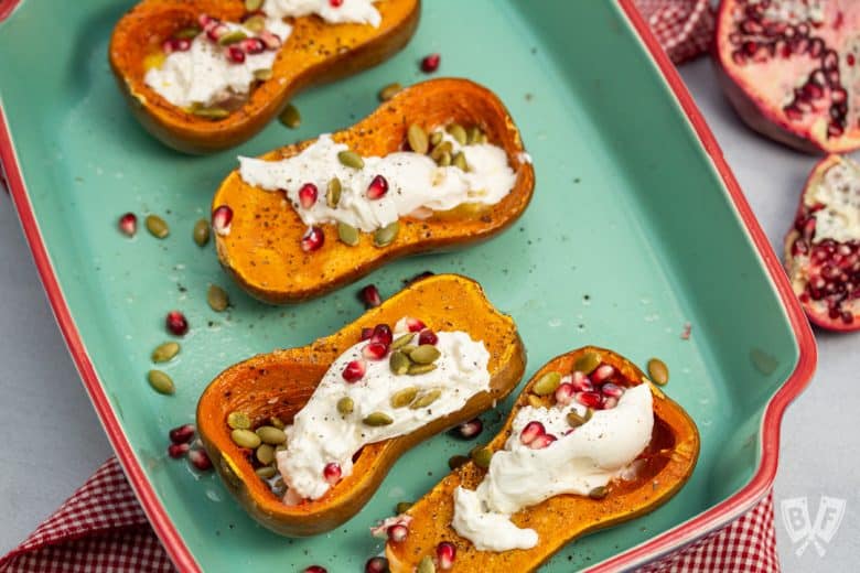 Roasted Honeynut Squash with Burrata, Pomegranate + Pepitas in a baking dish