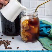 Pouring milk into a glass of cold brew coffee