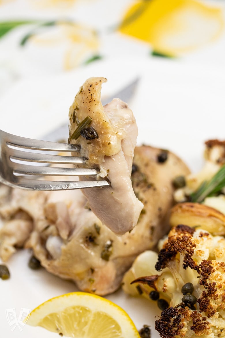 A fork with a bite of Roasted Lemon-Rosemary Chicken