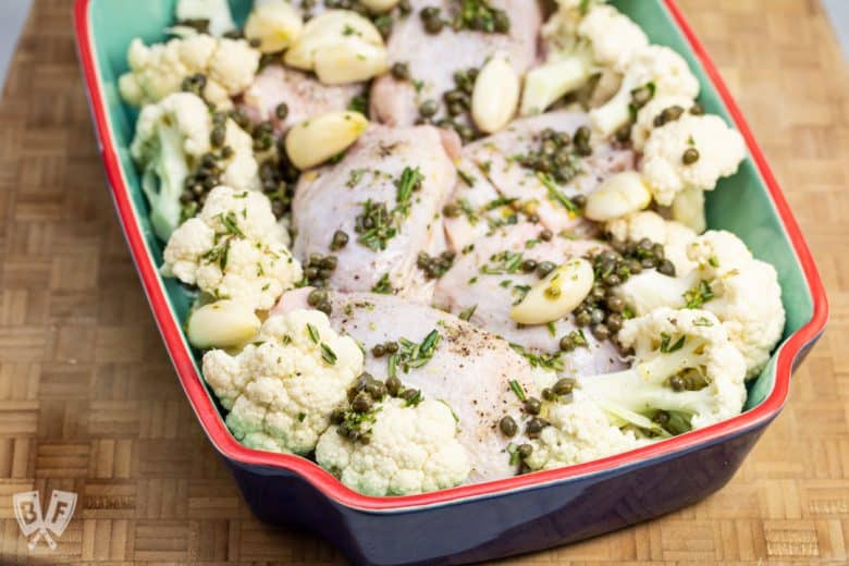 Chicken thighs and cauliflower with lemon rosemary garlic oil ready for the oven