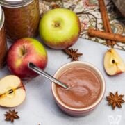 Instant Pot applesauce surrounded by apples and mulling spices.