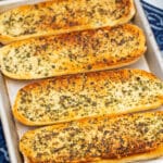 Overhead view of a tray of golden brown homemade garlic bread.